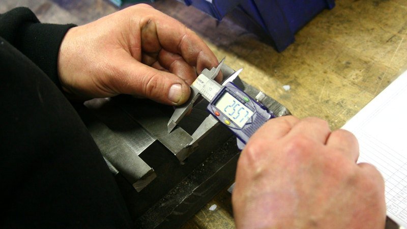 Engineer measuring a part with a vernier caliper