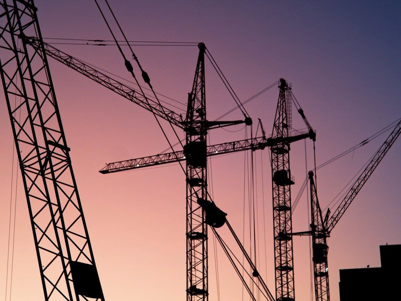 Construction cranes at dusk